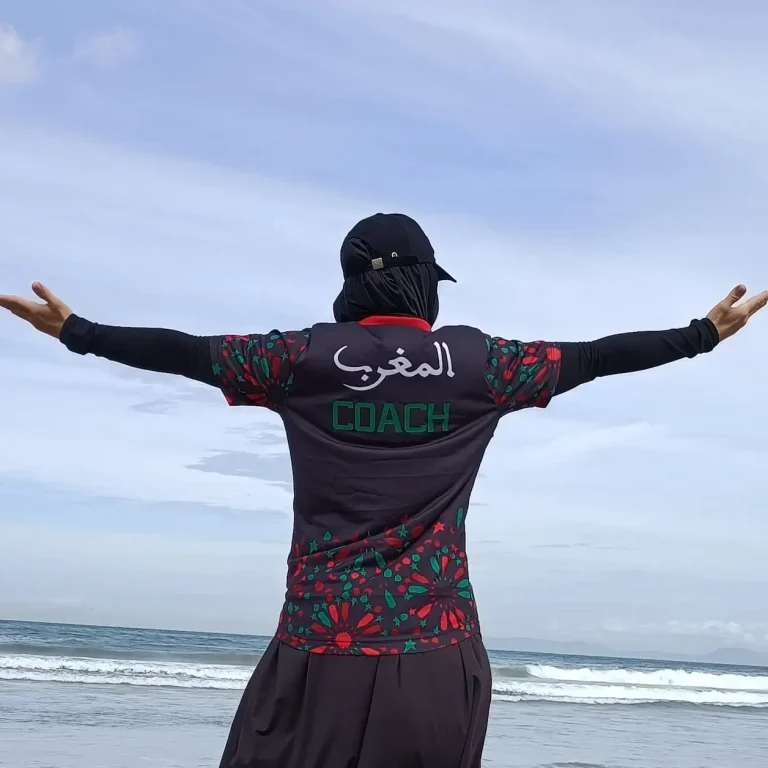 Coach Muslima Fit pensive en regardant la mer, réfléchit à comment rendre le sport accessible à toutes les femmes.