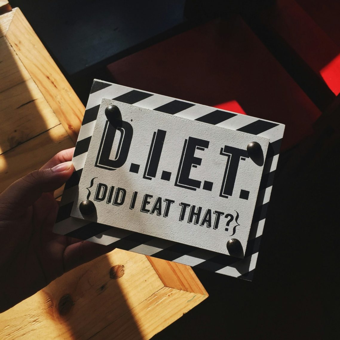Panneau noir et blanc avec le texte "D.I.E.T. (Did I Eat That?)" en lettres stylées.