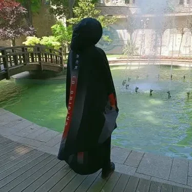 Femme portant un hijab noir, regard pensif, habillée en sport.