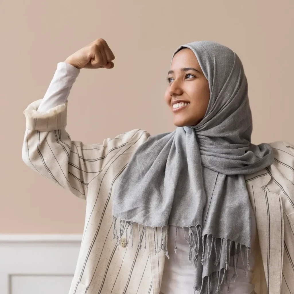 Femme en hijab, assise sur un tapis de gym, pratiquant des étirements fitness en groupe.