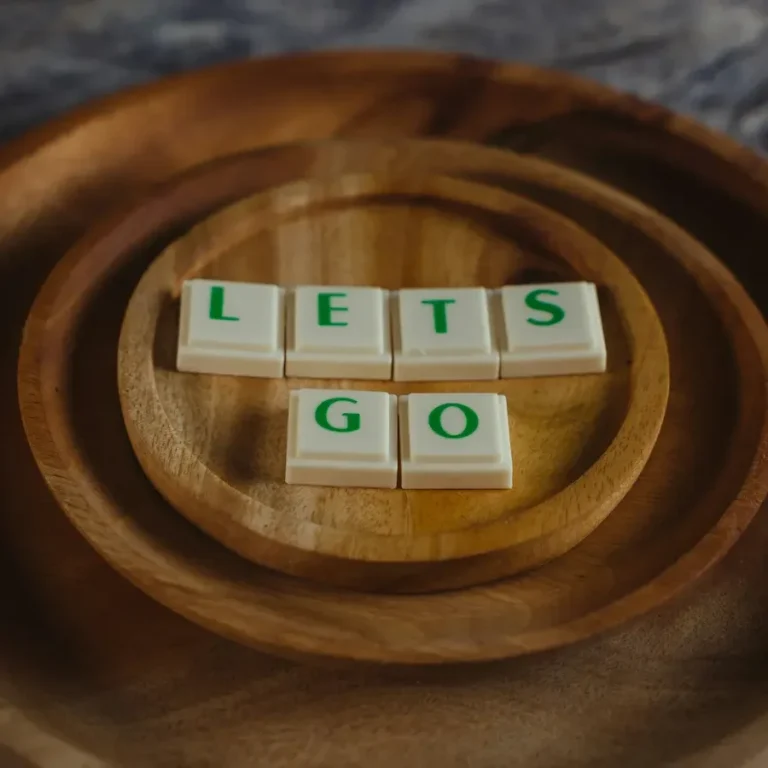 Lettres en dés sur un plat en bois : "LET’S GO".
