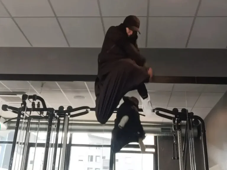 Un athlète effectue un saut acrobatique dans une salle de sport.